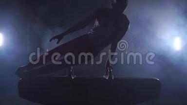 男子体操运动员在黑暗的<strong>背景</strong>上表演倒立和旋转鞍马，并缓慢地吸烟。 奥林匹克<strong>运动会</strong>